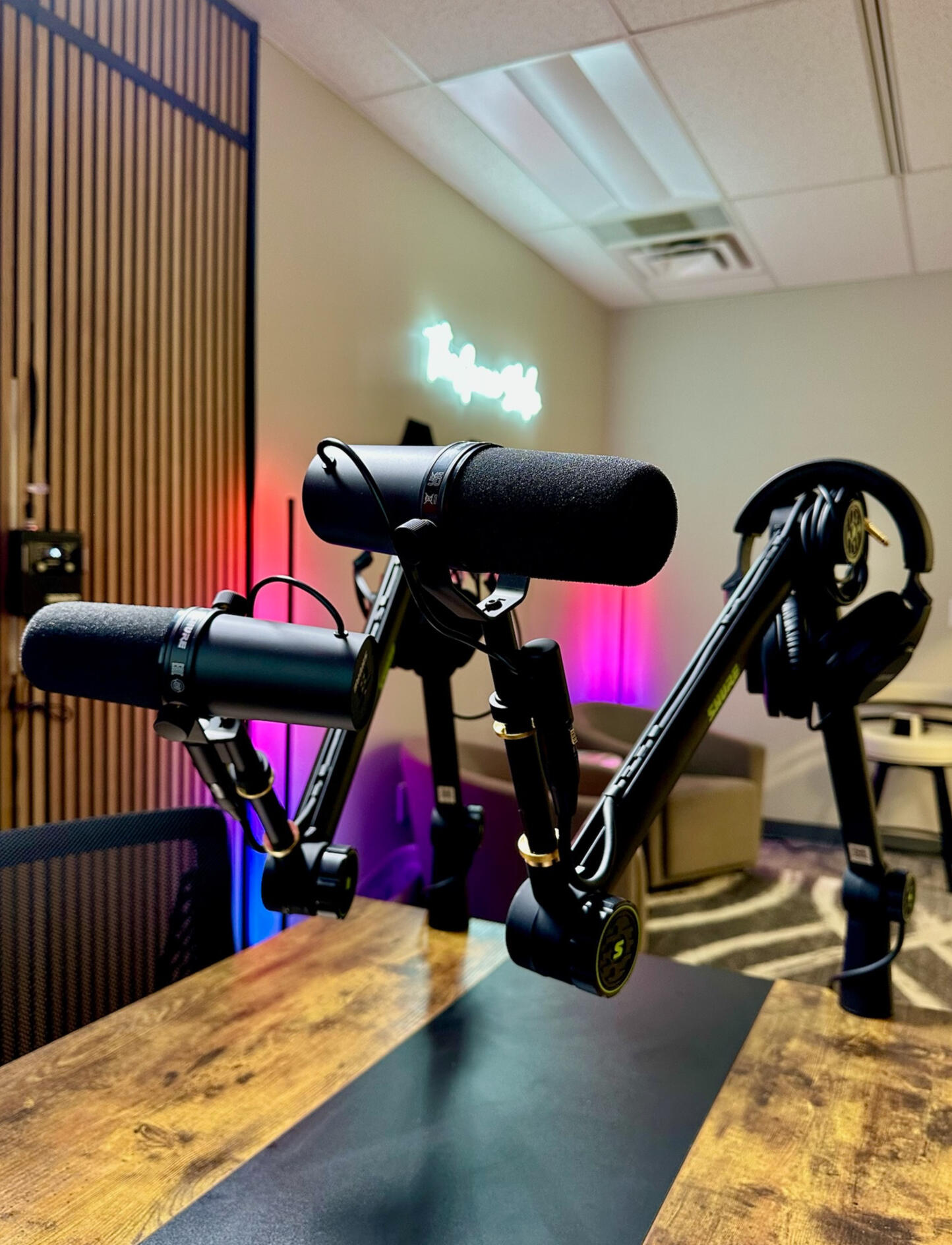 Professional podcast recording studio setup at The Groove Studio in Concord NC showing Shure SM7B microphones, audio equipment, and custom LED lighting with acoustic treatment panels